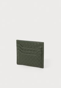 Tarjetero de cuero verde con textura trenzada, que cuenta con tres ranuras para tarjetas y costuras en contraste, de forma rectangular compacta.