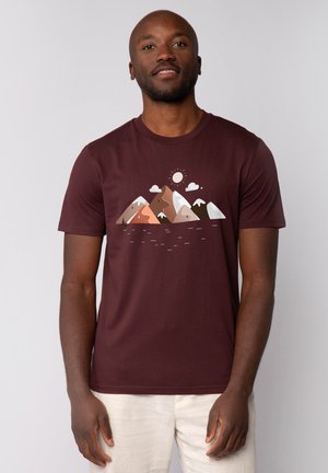 Bordeaux T-shirt met een bergafbeelding in tinten bruin, wit en groen, met een zon en wolken. Korte mouwen en een ronde halslijn.