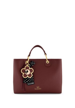 Borsa a mano in pelle bordeaux con manici dorati, charm a forma di fiore con nastro a pois bianco e nero e logo Braccialini in lettere dorate.