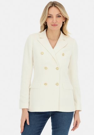 Dwurzędowa kremowa marynarka z teksturowanej tkaniny, z guzikami w kolorze złota, klapami z wycięciem oraz dwiema przednimi kieszeniami. Slim-fit.