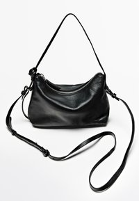 Black leather shoulder bag with a curved shape, single strap, and silver zipper detailing. Features a smooth texture and minimalistic design.