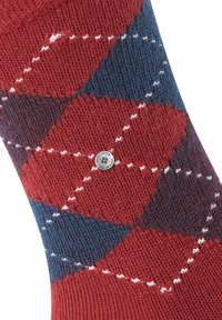 Calzino a rombi rossi e blu navy con accenti bianchi e lavorazione a maglia testurizzata, dotato di un piccolo logo circolare vicino alla parte superiore.