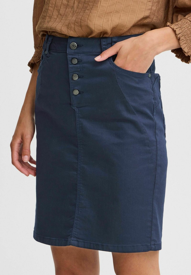 Gonna di denim blu navy con una forma aderente, caratterizzata da chiusura frontale con bottoni, tasche laterali e una texture liscia.