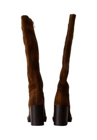 Bottes marron en daim au-dessus du genou avec un talon carré, des détails zippés et une texture lisse, mettant en avant une silhouette ajustée et un design minimaliste.