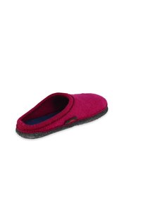 Burgunderfarbene Hausschuhe aus weichem Filz, mit runder Zehenpartie und einer strukturierten schwarzen Gummisohle. Mit einem Stoffetikett an der Seite.