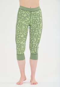 Green leggings with a repeating graphic pattern in a lighter shade of green. Features a fitted waist and cropped, ribbed cuffs.