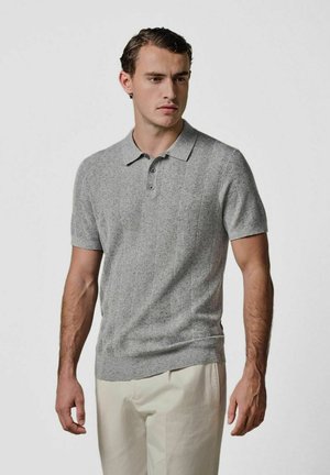 Szara teksturowana koszulka polo z krótkimi rękawami i kołnierzykiem, z trzema guzikami i dopasowanym krojem, w połączeniu z jasnymi spodniami.