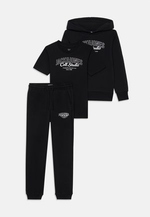 Zwart katoenen trainingspak bestaande uit een capuchontrui, T-shirt en joggers. Elk stuk heeft witte logo tekst aan de voorkant.