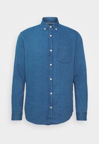 Skjorta med knappar i mörkblå herringbone-tyg med lång ärm, krage och bröstficka. Har vita knappar längs framsidan.