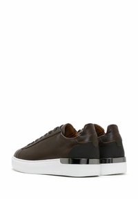 Brown leather sneakers with a smooth texture, white sole, and black accents. Features a round toe and minimalistic design.