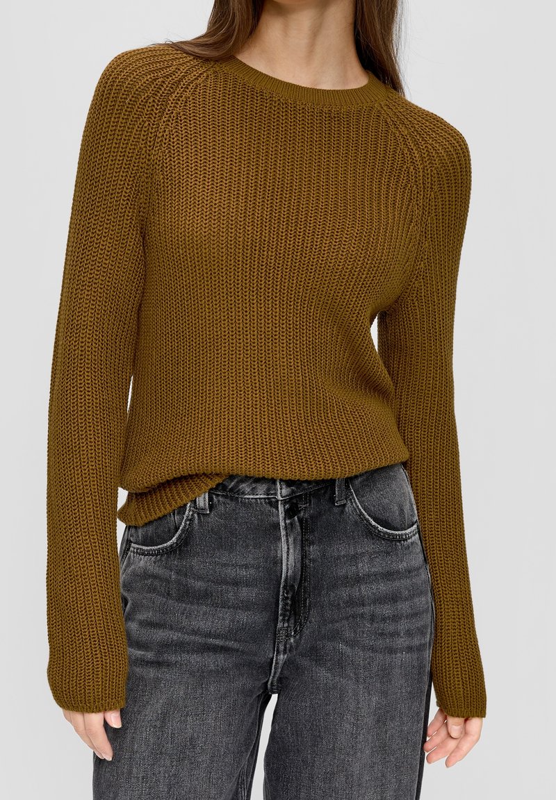 Maglione marrone lavorato a maglia con scollatura rotonda e maniche lunghe, abbinato a jeans in denim grigi a vita alta con un classico design a cinque tasche.