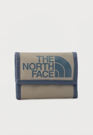 Cartera compacta de tela beige y azul con el logo de The North Face impreso en letras grandes azules en la solapa frontal.