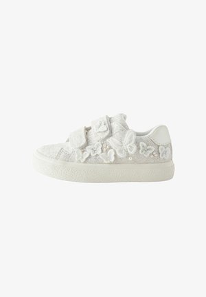 Witte sneaker met een glinsterende textuur, versierd met witte vlinder appliqués en dubbele klittenbandsluitingen. Gelaagde rubberen zool.