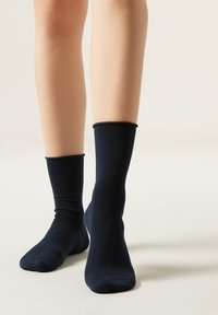 Calcetines de algodón de color marino con una textura suave y puños elásticos, que se ajustan perfectamente alrededor del tobillo, mostrando un diseño y color sencillos.