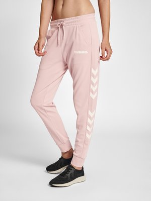 Roze sportbroek met een trekkoord in de taille, zijzakken en een wit chevronpatroon langs de zijkanten; zachte stof en taps toelopende boorden.