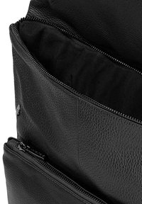 Černá kožená taška s texturovaným povrchem, která má několik kapsiček na zip. Vnitřek je podšitý černou látkou.