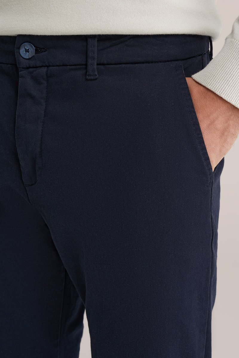 Mörkblå bomullsbyxor med slät front, sidofickor och knappstängning. Mjuk textur och skräddarsydd passform.