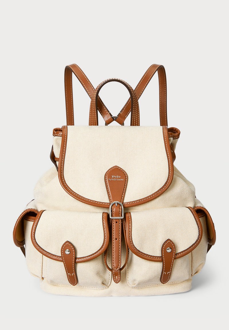 Bežinis drobės kuprinės su rudos odos akcentais, turinti priekį su užtrauktuku, dvi šonines kišenes ir reguliuojamas petnešas.