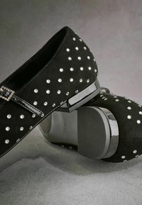 Scarpe nere in suede decorate con strass argentati, con punta arrotondata e tacco a blocco nero lucido. Includono un elegante dettaglio con fibbia.