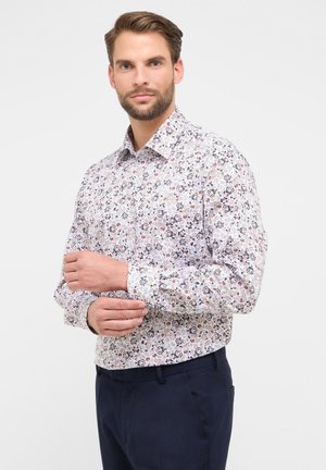 Camicia a maniche lunghe realizzata in tessuto leggero, caratterizzata da una base bianca con un motivo floreale nei toni del blu, rosso e marrone. Design con colletto classico.