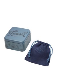 Boîte en métal bleu carré avec des motifs en relief noirs et le mot "Fossil". Comprend une pochette en tissu bleu foncé avec un cordon de serrage.