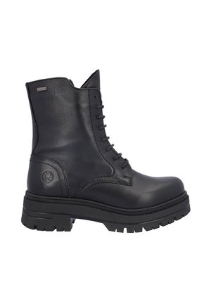 Bota de combate negra de cuero con cordones, suela gruesa de goma y caña hasta el tobillo, con una pequeña etiqueta metálica con el logo cerca del borde superior.
