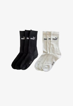 Three pairs of black and three pairs of white Puma crew socks with ribbed cuffs and logo on the ankle, size 35-38.