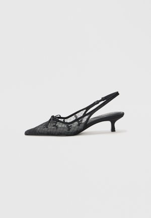 Escarpins noirs à talon slingback avec un bout pointu, présentant une tige en maille texturée avec des accents floraux et un petit talon chignon.