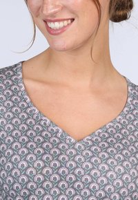 Graues V-Neck-Oberteil mit floralem Muster in Rosa- und Grüntönen. Weicher Stoff, eng anliegendes Design. Keine sichtbaren Beschläge oder Verzierungen.