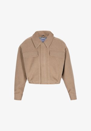 Beżowa krótka kurtka z szerokim kołnierzem, długimi rękawami i dwoma przednimi kieszeniami z klapkami, wykonana z miękkiego materiału przypominającego wełnę.