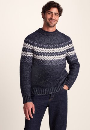 Navy knit sweater featuring a fair isle pattern in white and light gray, with a crew neck and ribbed cuffs and hem.