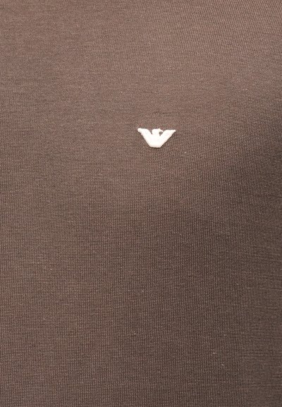 Καφέ υφασμάτινη υφή με ένα μικρό, λευκό κεντημένο λογότυπο αετού στο κέντρο.