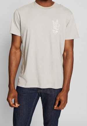 Light gray short-sleeve t-shirt made of soft fabric, featuring a graphic design on the left chest with leaf and block patterns.