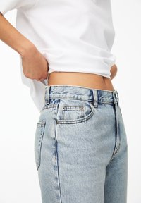 Ljust tvättade denimjeans med hög midja, slim fit, fem fickor och klassisk knapp- och dragkedjestängning. Mjukt material med lätt blekning.