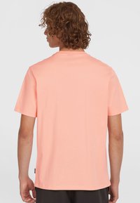 Korte mouwen T-shirt in licht koraal, gemaakt van zachte katoen. Heeft een ronde hals en een rechte zoom, met een discreet logo op de zijnaad.