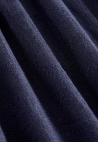 Tumši zils audums ar teksturētu, ribotu rakstu. Mīksts materiāls parāda smalku pinuma struktūru un neticamas krāsas nianses.