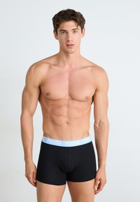 Boxerii negri cu un bandă elastică de culoare albastru deschis, pe care este inscriptionat "PUMA" în alb. Materialul pare neted și elastic, creat pentru confort.