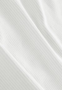 Tissu blanc texturé avec de subtiles nervures verticales, affichant des fibres douces et lisses ainsi qu'une surface légèrement brillante. Convient pour des vêtements ou de l'ameublement.