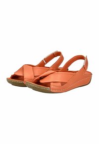 Sandales orange avec un design de bride croisée, fabriquées à partir d'un matériau synthétique lisse. Dotées d'un petit talon compensé avec une semelle texturée.
