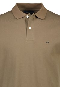 Khaki-paita, joka on valmistettu karheasta kankaasta, jossa on klassinen kaulus, kolme nappia ja pieni musta vuoristologo vasemmassa rinnassa.