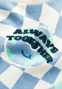 Sinise ja valge ruuduline kangas naeratava Maa graafikuga ja tekstiga "Always Together" tumedates tähtedes.