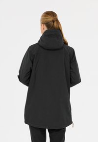 Svart huva jacka med längre skärning, med en slät textur, minimalistisk design och funktionella dragkedjor på sidorna.