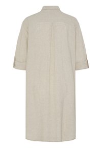 Iš ilgomis rankovėmis ir užlenktais rankogaliais, apykakle bei nugaroje esančia klostės detale, skirta patogesniam judesiui, pasiūta smėlio spalvos marškinėlių suknelė.