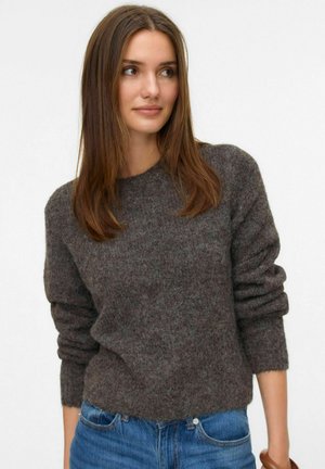 Dunkelgrauer Wollpullover mit Rundhalsausschnitt und langen, leicht puffigen Ärmeln; kombiniert mit blauen Jeans. Weicher Stoff und lässiger Schnitt.