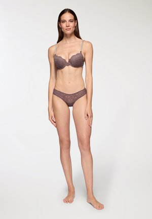 Reggiseno in pizzo e slip coordinato in un delicato colore malva. Il reggiseno presenta coppe sagomate, spalline regolabili e sottili motivi floreali. Lo slip è a vita bassa.
