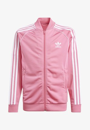 Różowa kurtka sportowa Adidas z białymi trzema paskami na rękawach, zamkiem błyskawicznym z przodu, prążkowanym kołnierzem, mankietami, dolnym ściągaczem i logo Adidas na piersi.