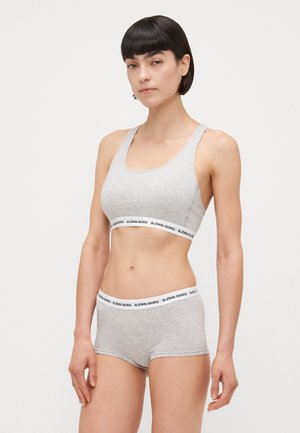Gray cotton sports bra and shorts set featuring a logo band in black and white. Simple design with a fitted cut and soft texture.