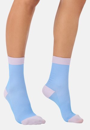 Hellblaue Knöchelsocken mit gerippter Textur, lila Bündchen und pink verstärktem Zehen- und Fersenbereich. Einfaches Design, das sich gut für legere Kleidung eignet.