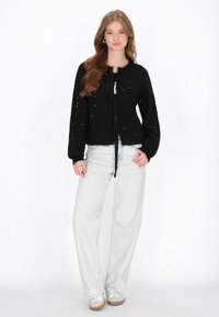 Czarny dziany kardigan z teksturowanym wykończeniem, z okrągłym dekoltem, zapięciem na guziki, długimi rękawami i krótkim krojem.