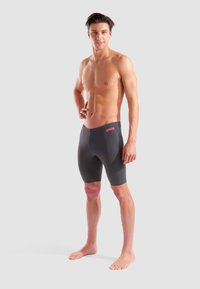 Herren Arena Schwimmshorts in Dunkelgrau, mit eng anliegendem Schnitt, glatter Textur und einem leuchtend roten Logo am Bund.